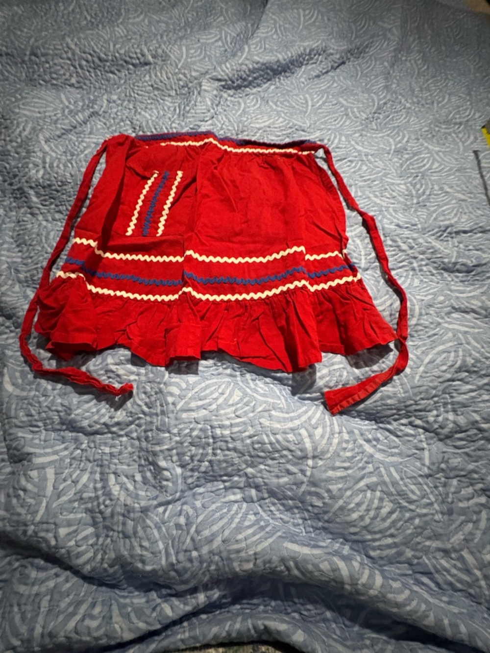 vintage red half waist apron with blue white ric rack.